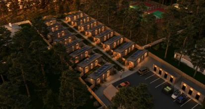Aerial night view of a Timbergon modular cottage community with lit windows