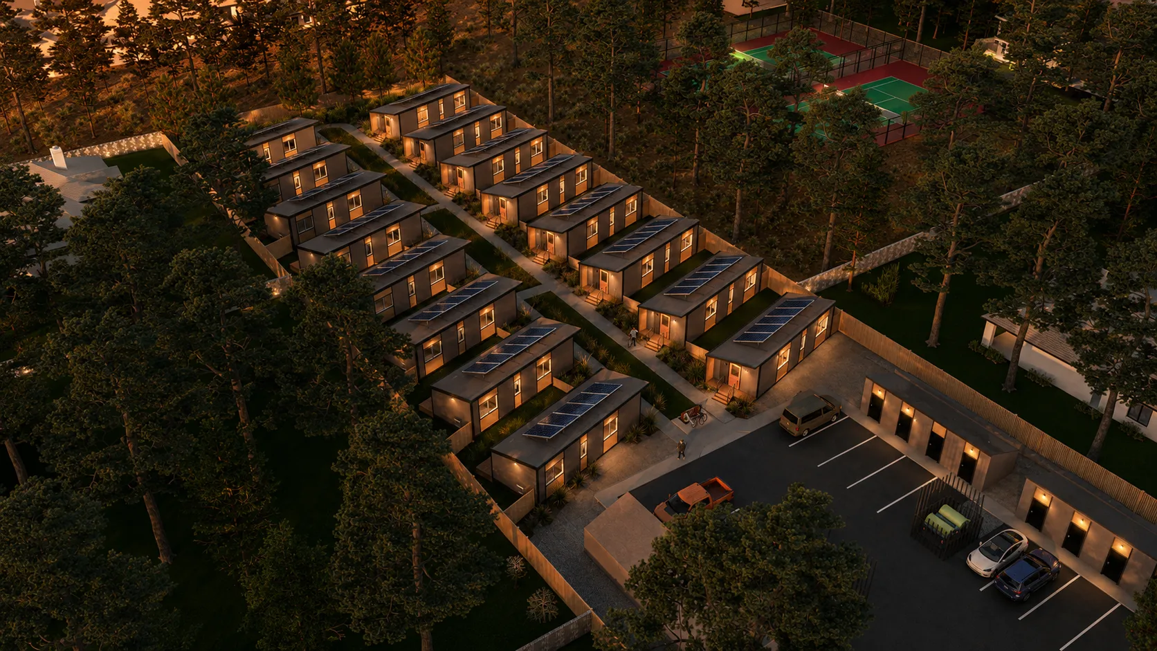 Aerial night view of a Timbergon modular cottage community with lit windows