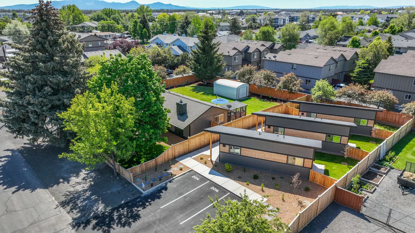 Overhead view of Timbergon modular ADU entries, walkways, numbered parking spaces, and private fenced yards