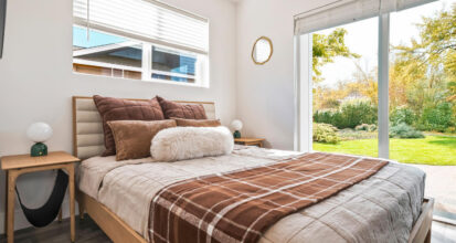 Modular ADU bedroom with a sliding glass door and garden view